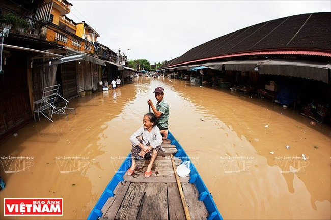 Tuyến đường Bạch Đằng bị ngập sáng 14/12 khiến nhiều người phải đi lại bằng thuyền. (Nguồn: Báo ảnh Việt Nam)