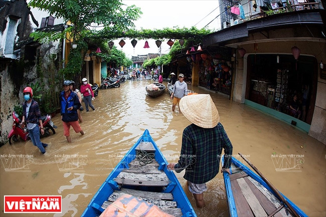 Người dân di chuyển bằng ghe thuyền. (Nguồn: Báo ảnh Việt Nam)