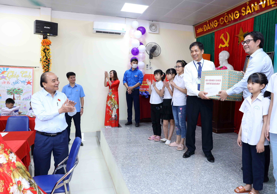 Chủ tịch nước Nguyễn Xuân Phúc chứng kiến các đơn vị tặng quà cho Trung tâm Nuôi dưỡng trẻ khuyết tật Hà Nội. (Ảnh An Đăng/TTXVN)