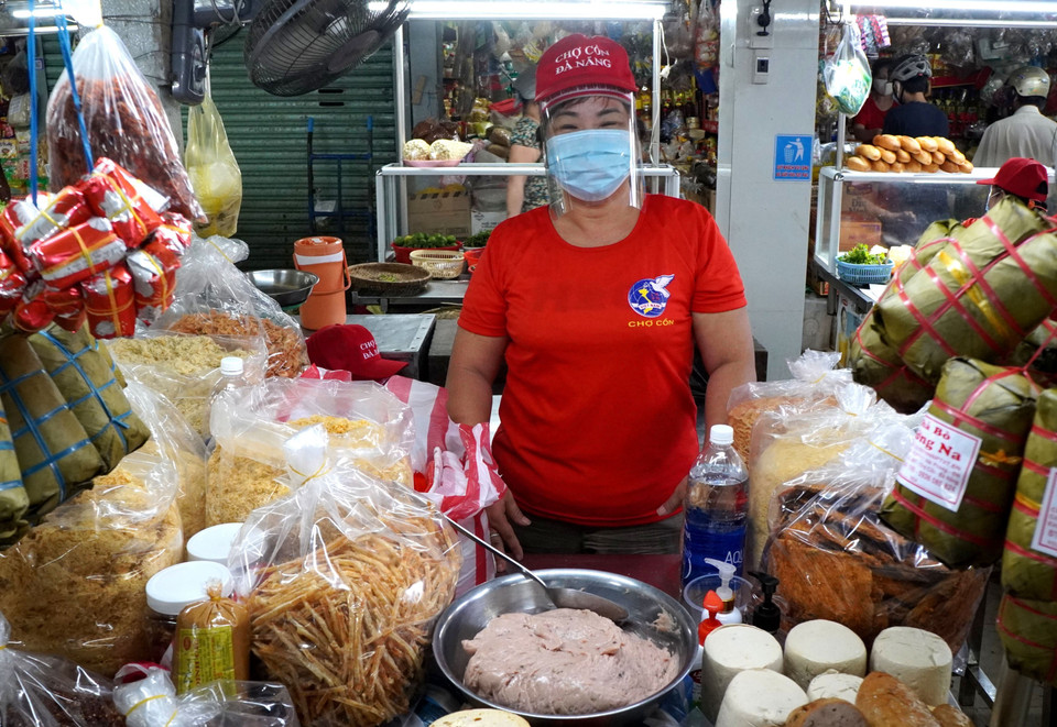 Một tiểu thương tại chợ Cồn với tinh thần lạc quan chiến thắng dịch bệnh. (Ảnh: Quốc Dũng/TTXVN)