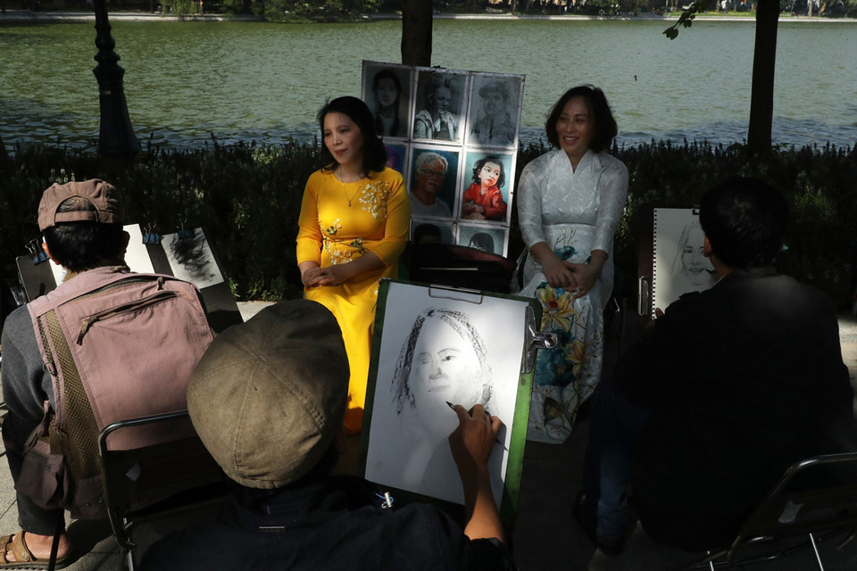 Những họa sỹ vẽ chân dung tại Không gian phố đi bộ hồ Hoàn Kiếm. (Ảnh: Lâm Khánh/TTXVN)