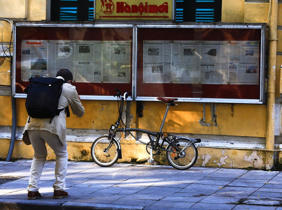 Một người đàn ông lưu lại khoảnh khắc bên chiếc xe đạp nhỏ ở tòa soạn báo Hà Nội Mới trên phố Lê Thái Tổ.(Ảnh: Lâm Khánh/TTXVN)