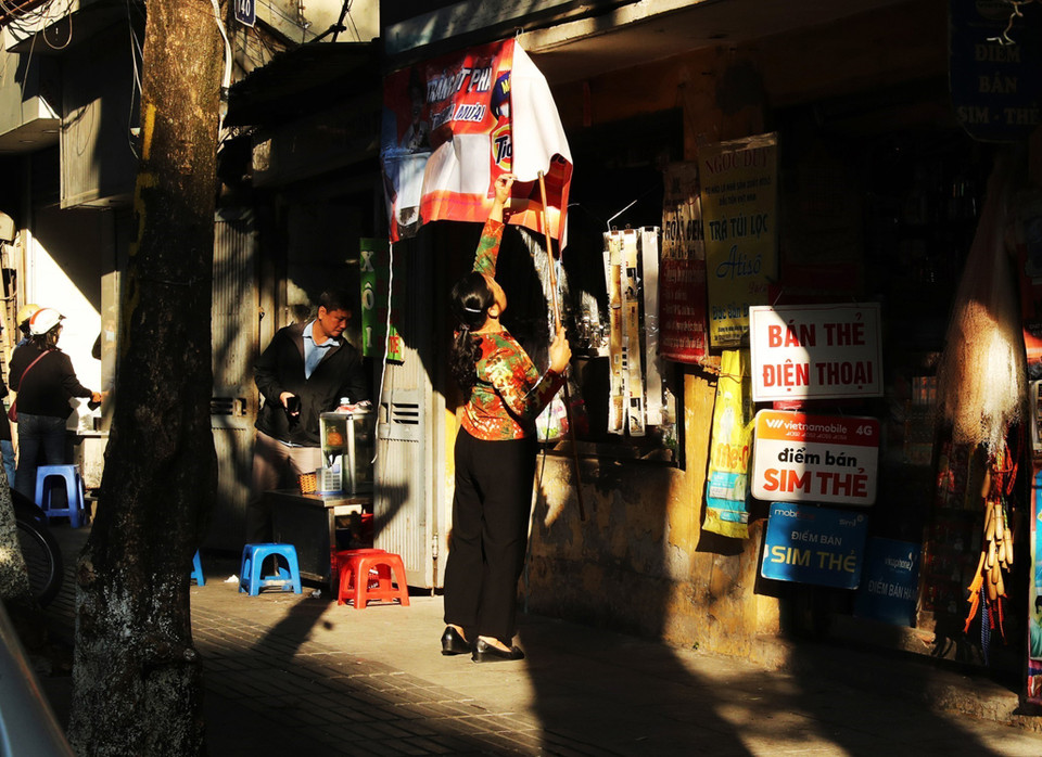 Nắng sớm đổ dài trên phố Quán Thánh, khi mà người dân bắt đầu mở cửa hàng kinh doanh. (Ảnh: Lâm Khánh/TTXVN)