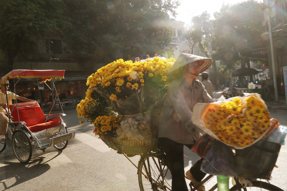 Một phụ nữ bán hàng hoa trên phố Nhà Thờ, quận Hoàn Kiếm. (Ảnh: Lâm Khánh/TTXVN)