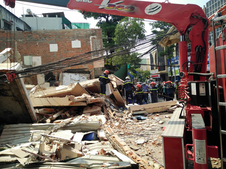 Lực lượng cứu hộ cứu nạn đang xử lý hiện trường vụ sập nhà. (Ảnh: Nguyên Linh/TTXVN)