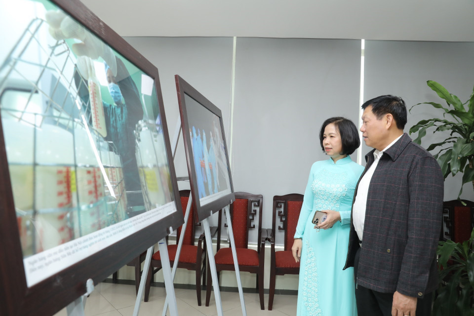 Tổng giám đốc TTXVN Vũ Việt Trang và Thứ trưởng Thường trực Bộ Y tế Đỗ Xuân Tuyên tham quan triển lãm ảnh về ngành y trưng bày tại trụ sở TTXVN. (Ảnh: Minh Quyết/TTXVN)