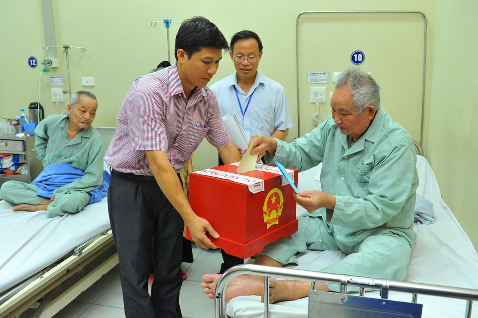 Nhân viên khu vực bỏ phiếu số 3, phường Bạch Đằng, quận Hai Bà Trưng (Hà Nội) mang hòm phiếu đến Bệnh viện Hữu Nghị để các bệnh nhân không tự vận động được bỏ phiếu bầu cử đại biểu Quốc hội khóa XIV. (Ảnh: Minh Đức/TTXVN)