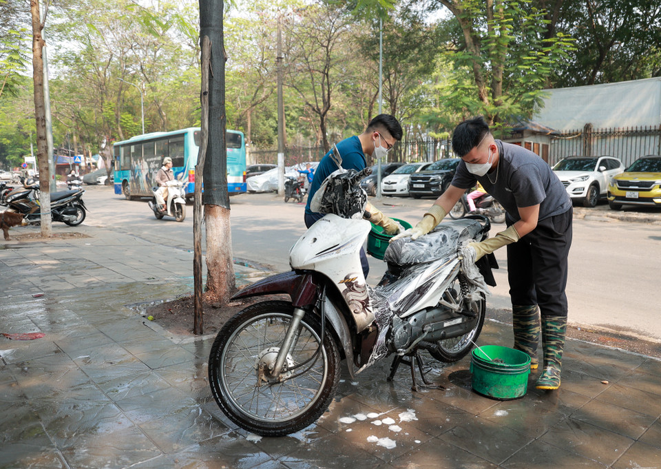Một số tiểu thương kinh doanh dịch vụ rửa xe vất tất bật trong ngày 30 Tết. (Ảnh: Minh Hiếu/Vietnam+)