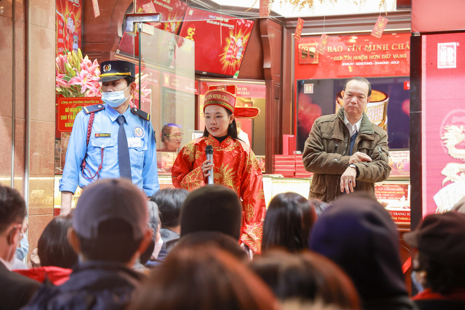 Các nhân viên cửa hàng vàng đến từ rất sớm để làm công tác chuẩn bị đồng thời cũng mặc trang phục Thần Tài thằm thu hút người đi đường. (Ảnh: Minh Hiếu/Vietnam+)