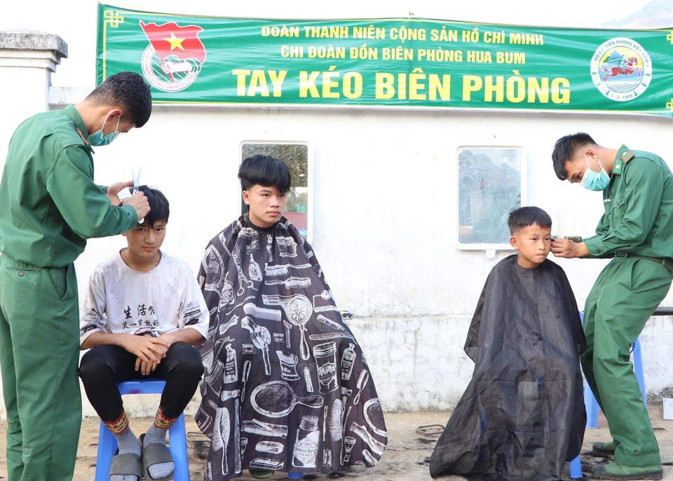 Chiến sỹ đồn Biên phòng Hua Bum cắt tóc cho con em đồng bào trên địa bàn xã Trung Chải, tỉnh Lai Châu. (Ảnh: Quý Trung/TTXVN)