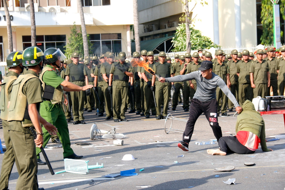 Lực lượng tham gia bảo vệ an ninh, trật tự ở cơ sở của Bình Thuận xử lý tình huống đối tượng quá khích khống chế con tin. (Ảnh: Nguyễn Thanh/TTXVN)