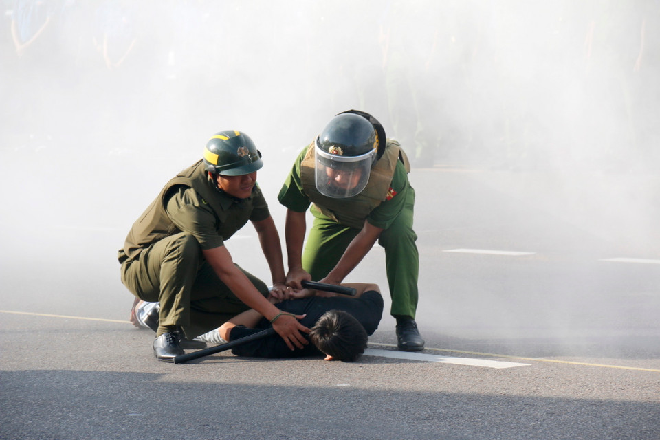 Lực lượng tham gia bảo vệ an ninh, trật tự ở cơ sở của Bình Thuận xử lý tình huống khống chế đối tượng quá khích, chống đối lực lượng chức năng. (Ảnh: Nguyễn Thanh/TTXVN)