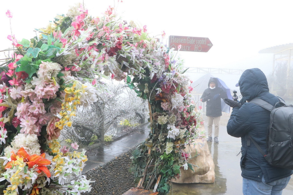 Du khách thích thú trải nghiệm hiện tượng băng giá trên đỉnh Ô Quý Hồ. (Ảnh: Nguyễn Oanh/TTXVN)