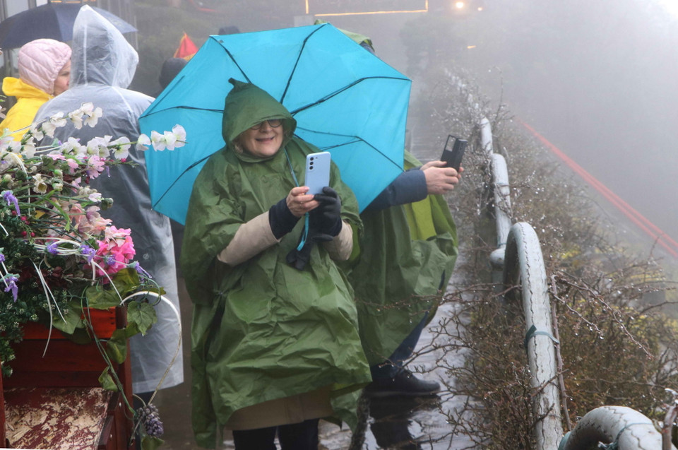Du khách nước ngoài thích thú dùng ghi lại khoảnh khác băng giá tại đỉnh Ô Quý Hồ. (Ảnh: Nguyễn Oanh/TTXVN)