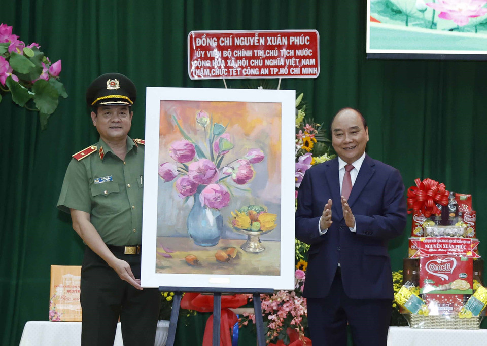 Chủ tịch nước Nguyễn Xuân Phúc tặng quà lưu niệm cho Công an Thành phố Hồ Chí Minh. (Ảnh: Thống Nhất/TTXVN)