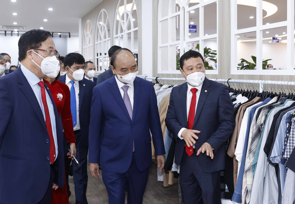 Chủ tịch nước Nguyễn Xuân Phúc thăm dây chuyền sản xuất của Tổng công ty May 10. (Ảnh: Thống Nhất/TTXVN)