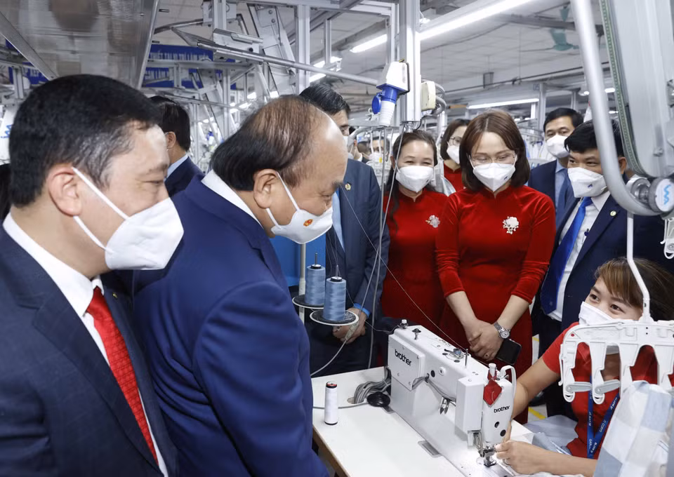 Chủ tịch nước Nguyễn Xuân Phúc thăm dây chuyền sản xuất của Tổng công ty May 10. (Ảnh: Thống Nhất/TTXVN)