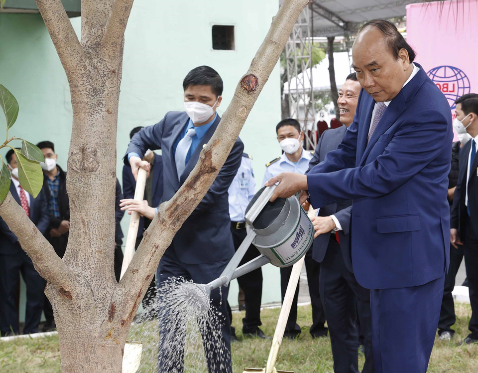 Chủ tịch nước Nguyễn Xuân Phúc thăm, trồng cây lưu niệm tại khuôn viên Tổng công ty May 10. (Ảnh: Thống Nhất/TTXVN)