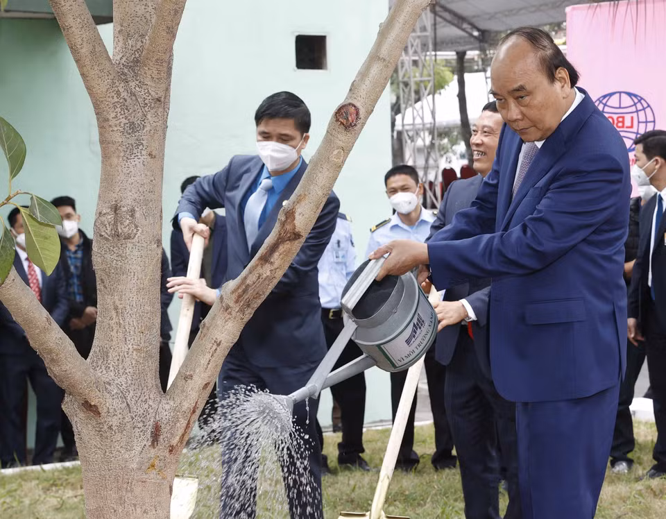 Chủ tịch nước Nguyễn Xuân Phúc thăm, trồng cây lưu niệm tại khuôn viên Tổng công ty May 10. (Ảnh: Thống Nhất/TTXVN)