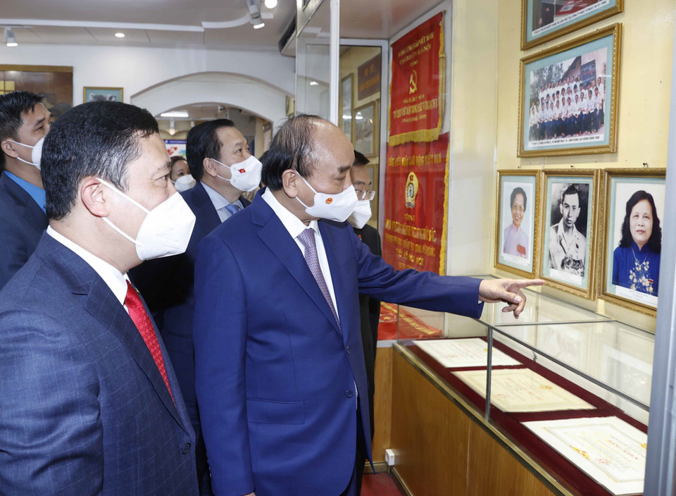 Chủ tịch nước Nguyễn Xuân Phúc thăm phòng truyền thống của Tổng công ty May 10. (Ảnh: Thống Nhất/TTXVN)