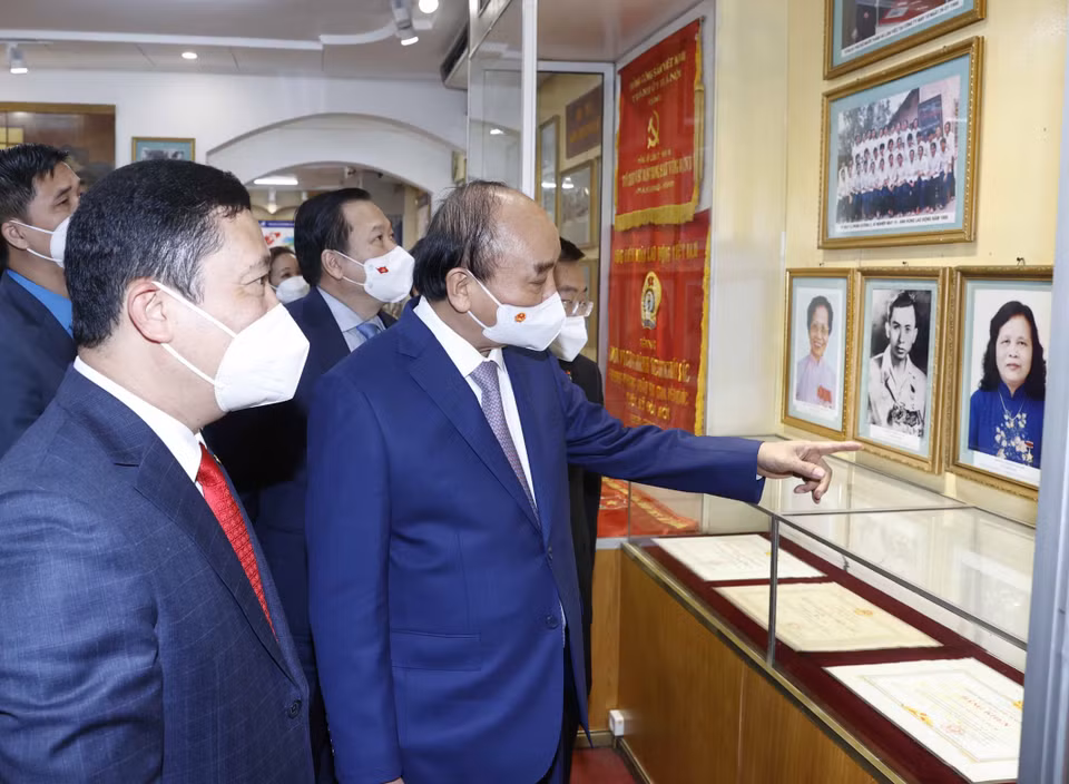 Chủ tịch nước Nguyễn Xuân Phúc thăm phòng truyền thống của Tổng công ty May 10. (Ảnh: Thống Nhất/TTXVN)