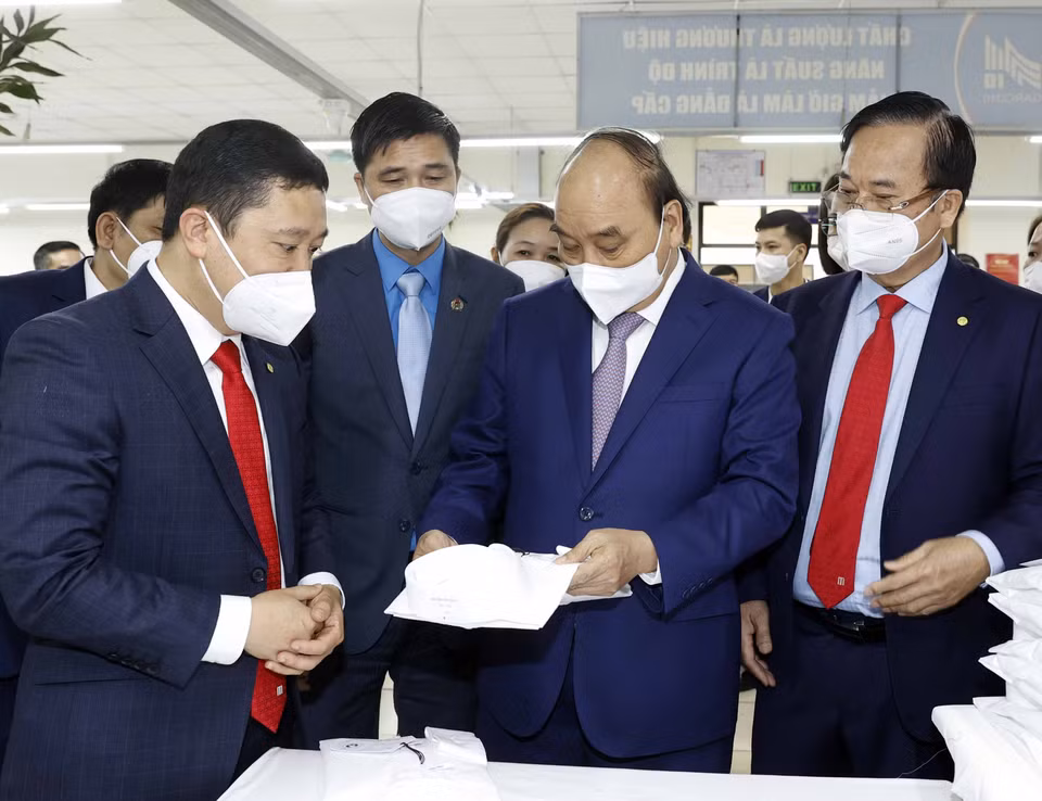 Hình ảnh Chủ tịch nước Nguyễn Xuân Phúc thăm dây chuyền sản xuất của Tổng công ty May 10. (Ảnh: Thống Nhất/TTXVN)