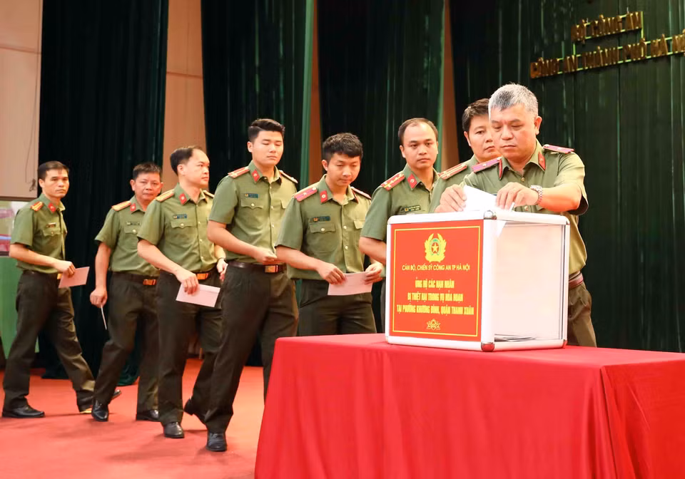 Cán bộ, chiến sỹ Công an thành phố Hà Nội ủng hộ các nạn nhân đã tử vong trong vụ cháy chung cư mini tại phố Khương Hạ (Thanh Xuân, Hà Nội). (Ảnh: Phạm Kiên/TTXVN)