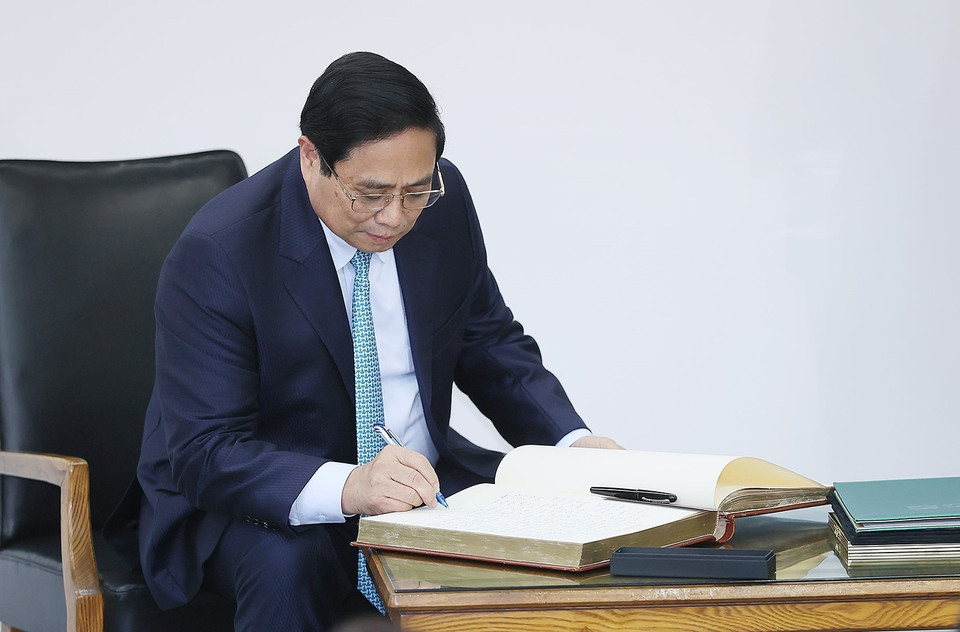 Thủ tướng Phạm Minh Chính viết sổ lưu niệm khi đến thăm Trường Đại học Kỹ thuật Xây dựng Bucharest. (Ảnh: Dương Giang/TTXVN)