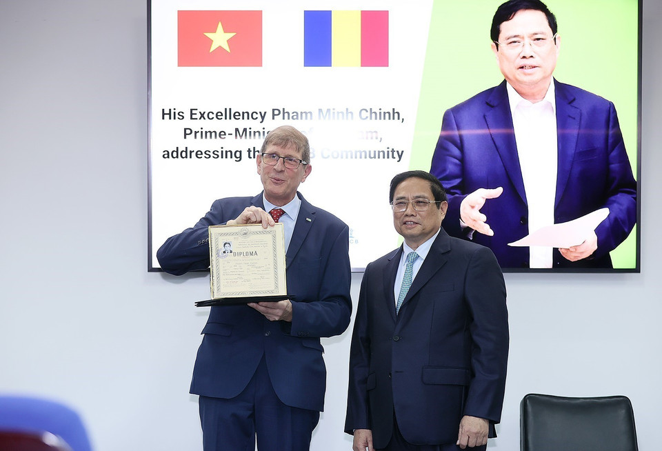 Thủ tướng Phạm Minh Chính tiếp nhận hồ sơ sinh viên từ lãnh đạo Trường Đại học Kỹ thuật Xây dựng Bucharest. (Ảnh: Dương Giang/TTXVN)