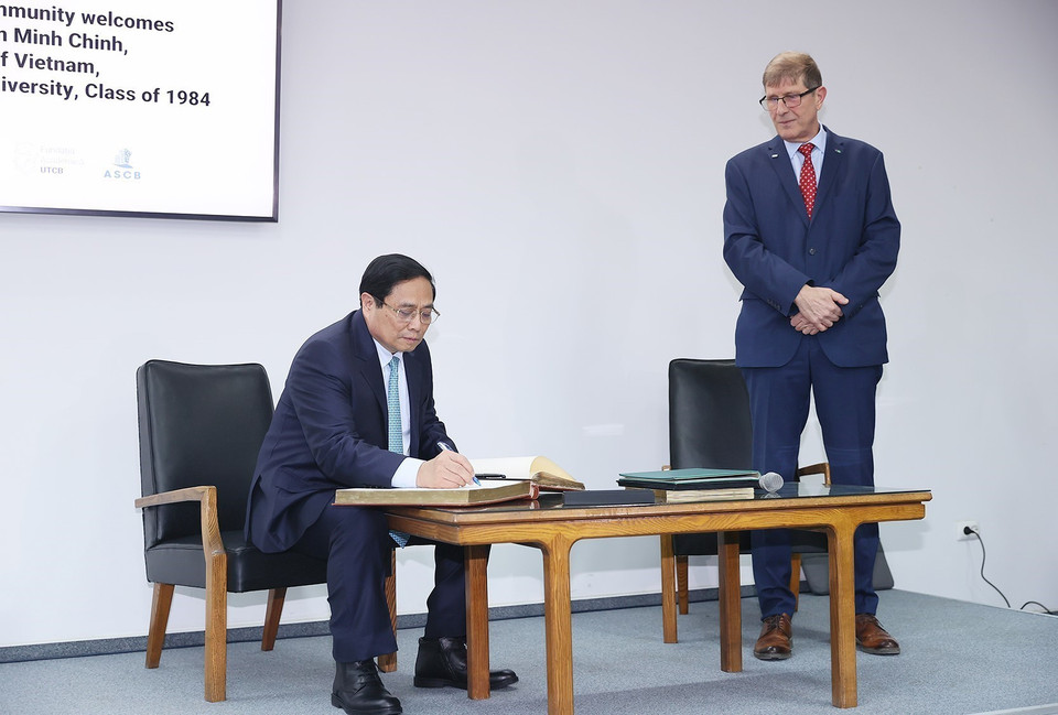 Thủ tướng Phạm Minh Chính viết sổ lưu niệm khi đến thăm Trường Đại học Kỹ thuật Xây dựng Bucharest. (Ảnh: Dương Giang/TTXVN)