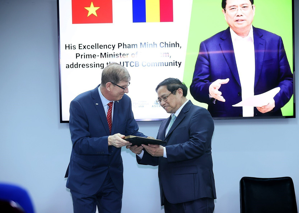 Thủ tướng Phạm Minh Chính tiếp nhận hồ sơ sinh viên từ lãnh đạo Trường Đại học Kỹ thuật Xây dựng Bucharest. (Ảnh: Dương Giang/TTXVN)