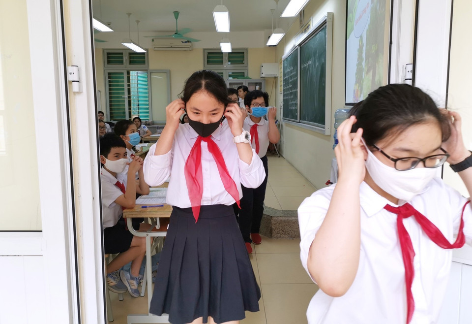 Học sinh trường THCS Trưng Vương thực hiện đeo khẩu trang khi hết tiết học ra khỏi lớp. (Ảnh: Thành Đạt/TTXVN)