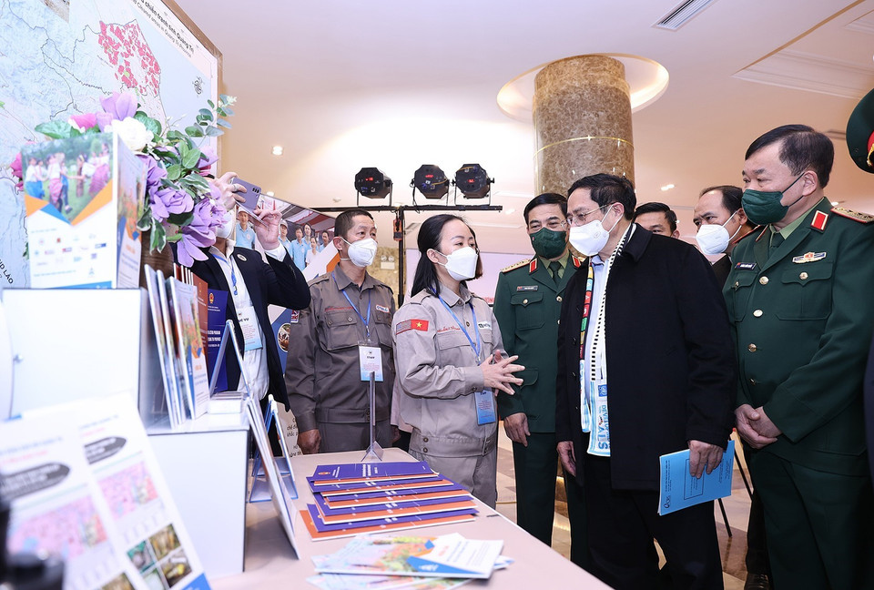 Hình ảnh Thủ tướng Phạm Minh Chính tham quan trưng bày ảnh, sách, báo, tuyên truyền về phòng tránh bom mìn. (Ảnh: Dương Giang/TTXVN)