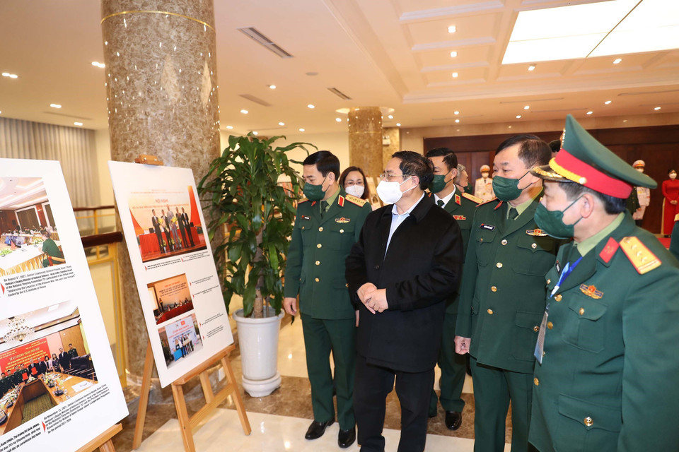 Thủ tướng Phạm Minh Chính và các đại biểu tham quan trưng bày ảnh về hậu quả bom mìn bên lề hội nghị. (Ảnh: Trọng Đức/TTXVN)