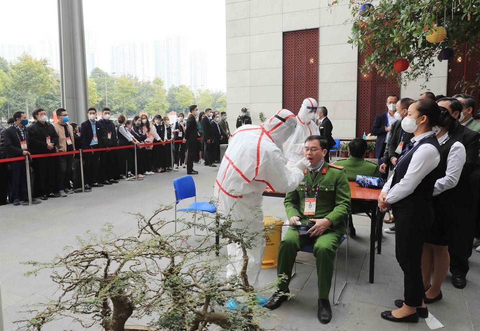 Nhân viên y tế lấy mẫu xét nghiệm các chiến sỹ công an phục vụ Đại hội XIII của Đảng, sáng 29/1. (Ảnh: TTXVN)