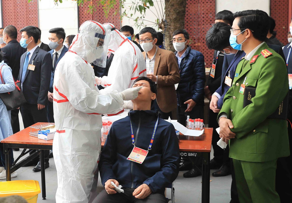 Nhân viên y tế lấy mẫu xét nghiệm các thành viên phục vụ Đại hội XIII của Đảng, sáng 29/1. (Ảnh: TTXVN)