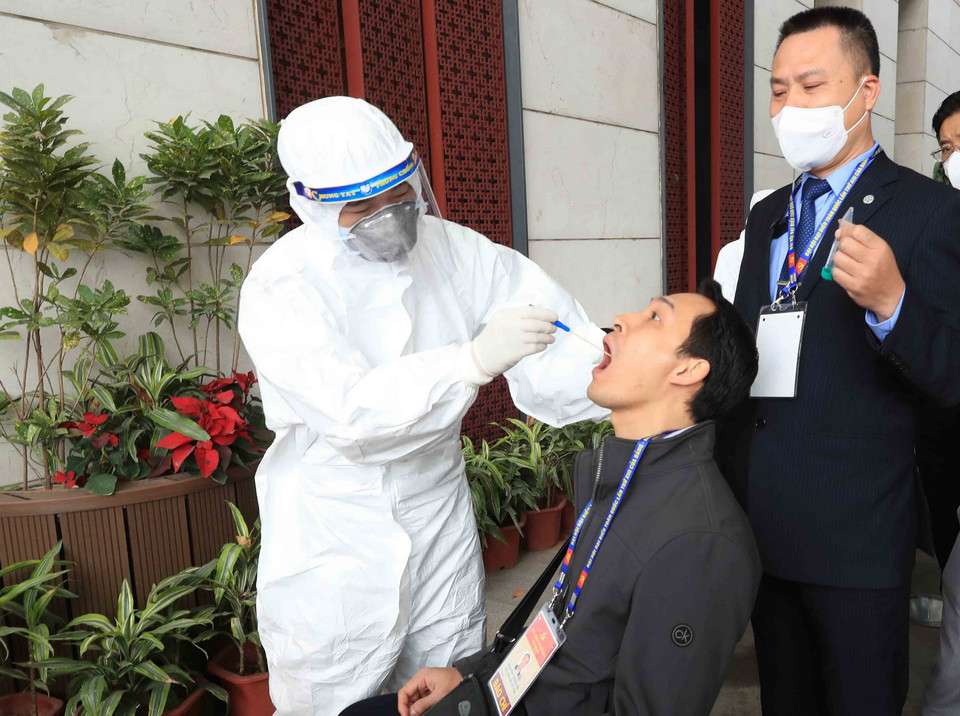 Nhân viên y tế lấy mẫu xét nghiệm phóng viên cơ quan báo chí phục vụ Đại hội XIII của Đảng, sáng 29/1. (Ảnh: TTXVN)