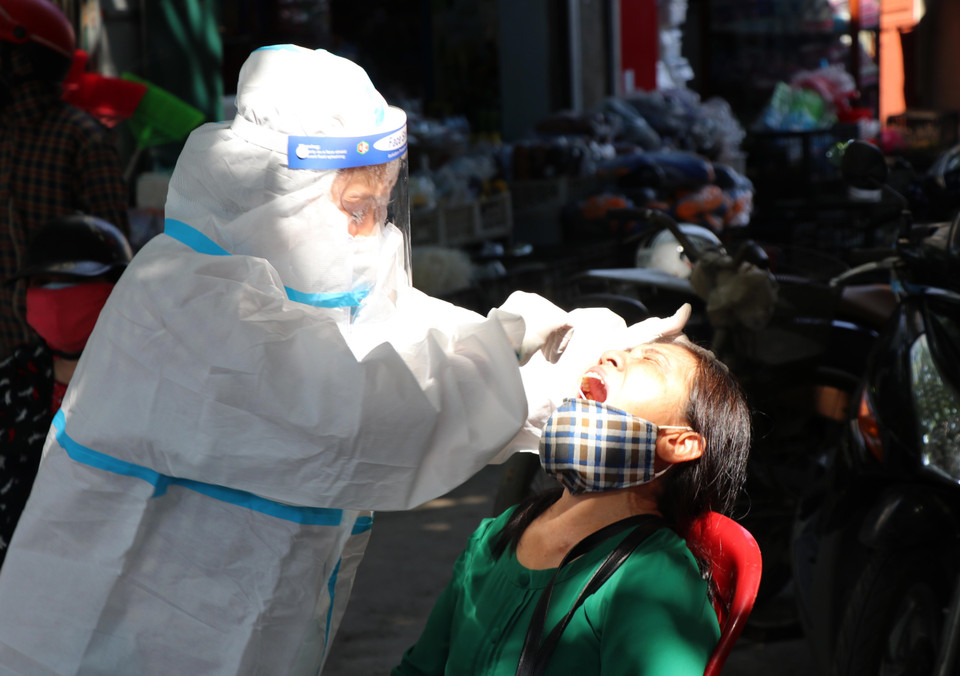 Tiến hành lấy mẫu xét nghiệm cho các tiểu thương kinh doanh, buôn bán tại các chợ trên địa bàn gần vùng thiết lập cách ly. (Ảnh: Xuân Tiến/TTXVN) 