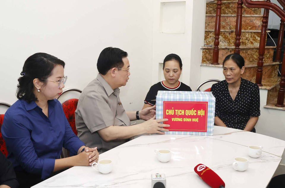 Chủ tịch Quốc hội Vương Đình Huệ thăm hỏi hộ dân sống liền kề chung cư mini lúc xảy ra vụ việc đã giúp đỡ người dân thoát nạn. (Ảnh: Doãn Tấn/TTXVN)