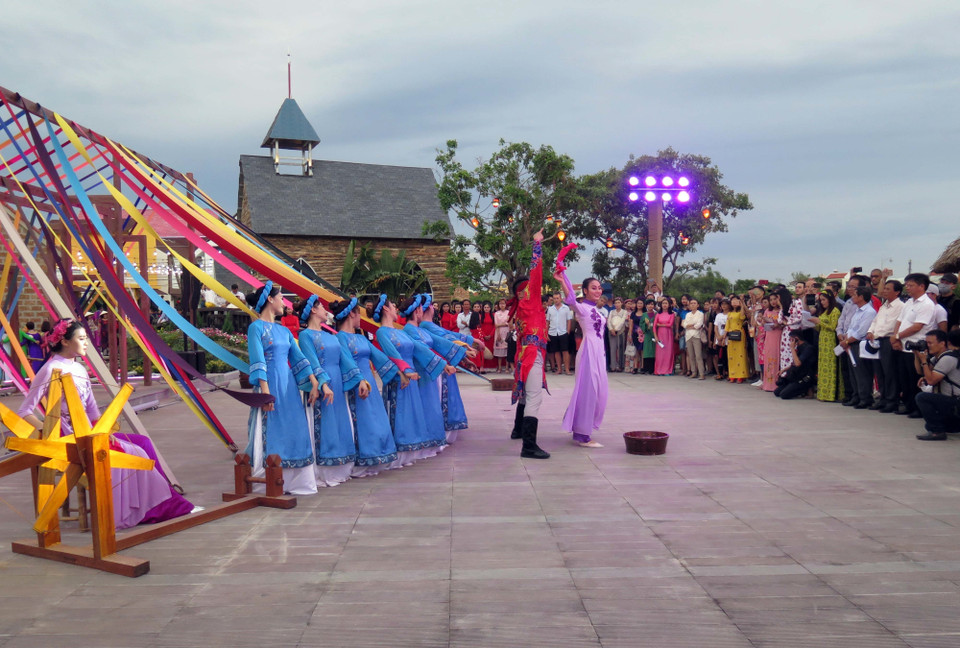 Trong ảnh: Màn biểu diễn múa tơ lụa ở Công viên Ấn tượng Hội An thu hút sự chú ý của nhiều du khách. (Ảnh: Đỗ Trưởng/TTXVN)