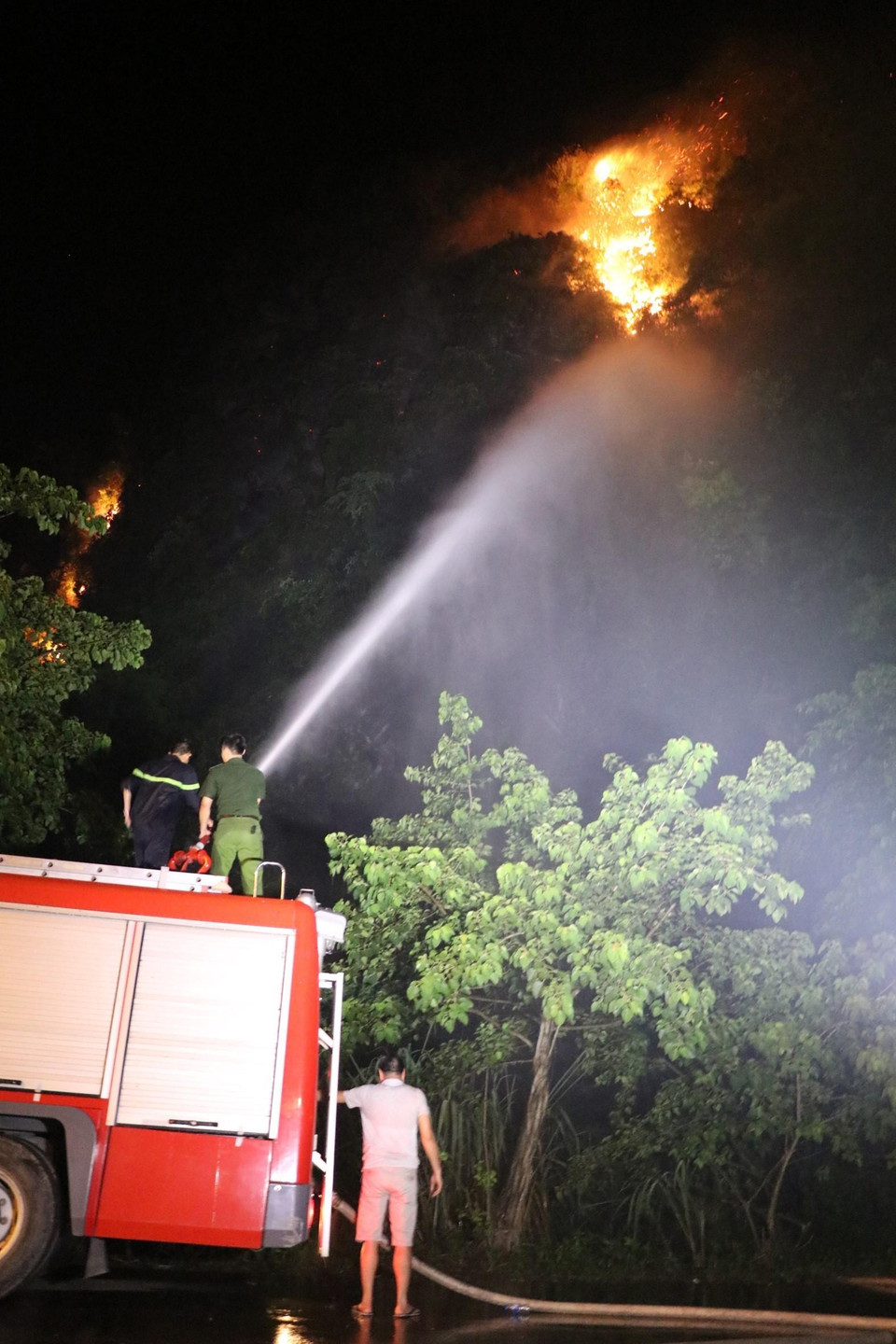 Đoạn đường Tràng An chạy qua chân núi Vụng Quao được phong tỏa để phục vụ công tác chữa cháy. (Ảnh: Ninh Đức Phương/TTXVN)