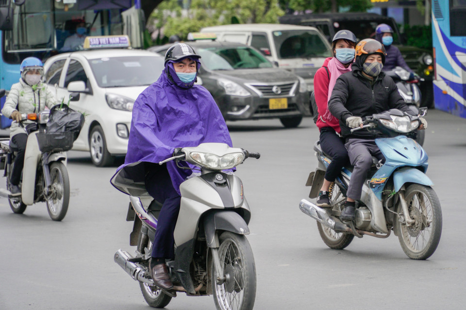 Một số chủ phương tiện tham gia giao thông phải mặc đủ loại mọi trang phục để chống chọi thời tiết lạnh thấu xương. (Ảnh: Minh Hiếu/Vietnam+)