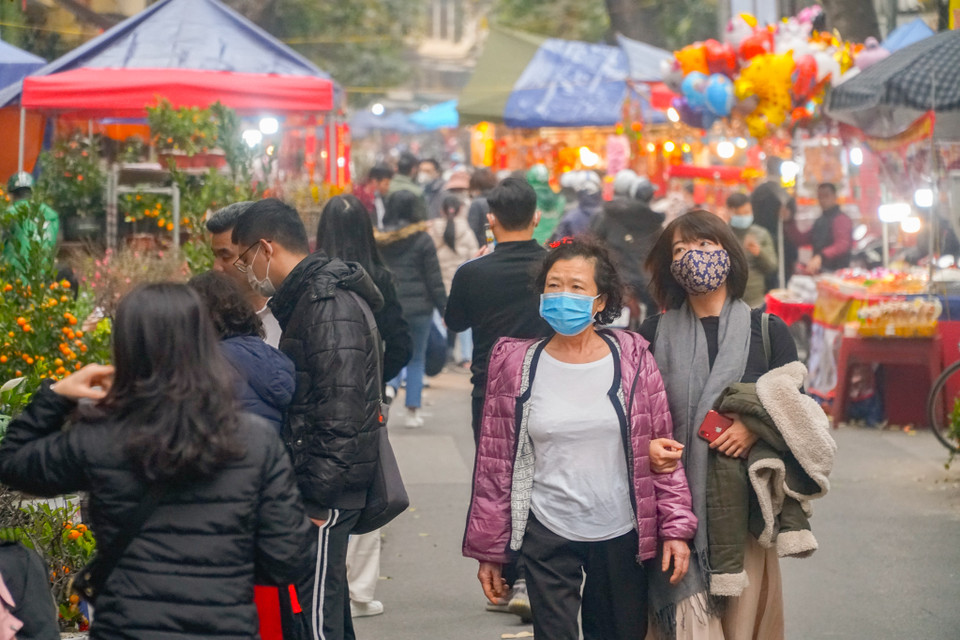Trong thời gian diễn ra chợ hoa Tết truyền thống, quận Hoàn Kiếm yêu cầu các phường trên địa bàn bố trí lực lượng ứng trực tại các cổng ra vào khu vực chợ thực hiện đo thân nhiệt, yêu cầu người ra vào khu vực chợ hoa Tết phải đeo khẩu trang, rửa tay bằng dung dịch sát khuẩn, nhằm đảm bảo an toàn cho người dân trước tình hình dịch COVID-19 đang lây lan. (Ảnh: Minh Hiếu/Vietnam+)