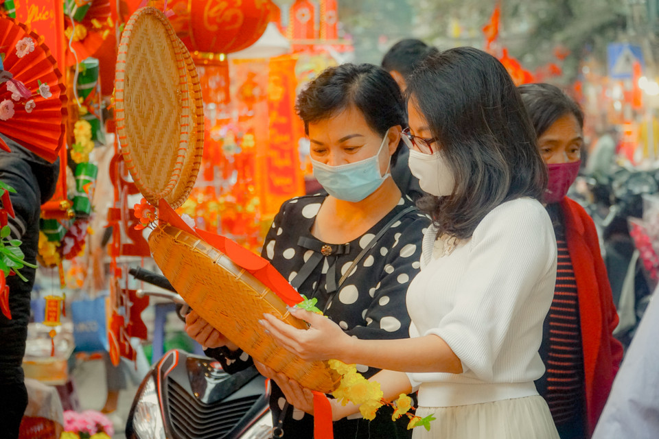 Chị Lã Thu Giang (phố Đội Cấn, Hà Nội) cùng mẹ đang lựa chọn đồ trang trí Tết. Chị chia sẻ: “Mình thấy Hàng Mã bày bán rất nhiều đồ trang trí Tết với màu sắc rực rỡ, nên tranh thủ lên phố Hàng Mã tham quan, mua sắm và chụp ảnh. Không khí Tết ở đây rất nhộn nhịp, có nhiều món đồ đẹp, lạ mà giá cả lại phải chăng." (Ảnh: Minh Hiếu/Vietnam+)
