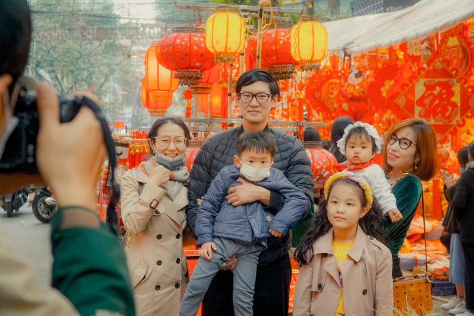 Không chỉ là nơi mua sắm đồ trang trí lý tưởng, phố Hàng Mã còn là điểm tham quan chụp ảnh lý tưởng của người dân trong nước và du khách nước ngoài, cùng nhau như tận hưởng không khí Hà Nội những ngày cuối năm. (Ảnh: Minh Hiếu/Vietnam+)