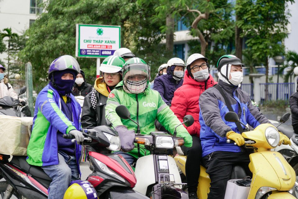 Những tài xế xe công nghệ trang bị đầy đủ quần áo dày dặn để giữ ấm. (Ảnh: Minh Hiếu/Vietnam+)