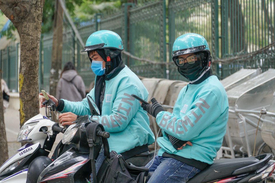 Vì miếng cơm manh áo, người lao động vẫn trơ chọi ngoài đường hứng từng cơn lạnh. (Ảnh: Minh Hiếu/Vietnam+) 