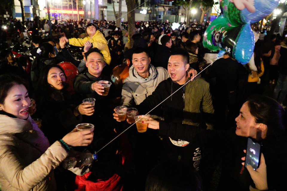 Mỗi người tới từ một nơi, với những câu chuyện khác nhau nhưng hôm nay họ sẽ cùng nhau chia sẻ một niềm vui lớn, cùng nhau chờ đợi thời khắc năm mới và gửi tới nhau những lời chúc hạnh phúc. (Ảnh: Minh Hiếu/Vietnam+)
