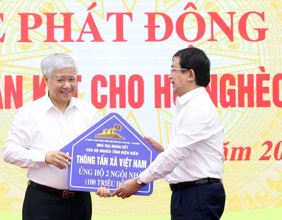 Phó Tổng Giám đốc Thông tấn xã Việt Nam Nguyễn Tuấn Hùng trao ủng hộ làm nhà Đại đoàn kết cho hộ nghèo của tỉnh Điện Biên. (Ảnh: Thống Nhất/TTXVN)