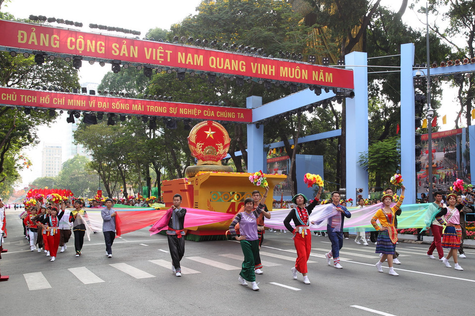 Đi đầu là Quốc huy nước Cộng hòa Xã hội Chủ nghĩa Việt Nam trên nền trống đồng, biểu hiện ý chí khát vọng của dân tộc Việt Nam. (Nguồn: TTXVN)